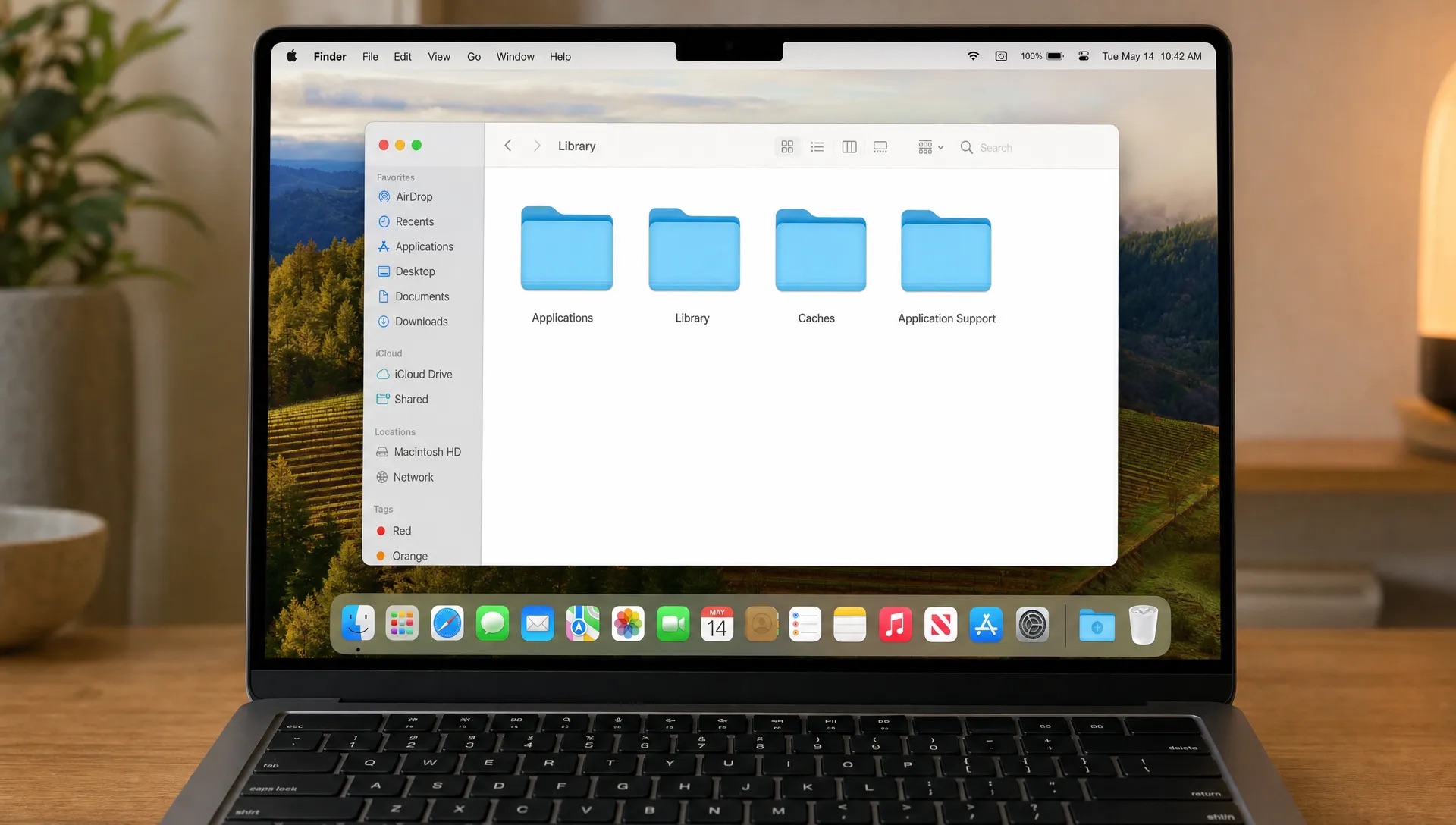A Finder window on a MacBook shows Applications, Library, Caches and Application Support folders during a careful app cleanup.