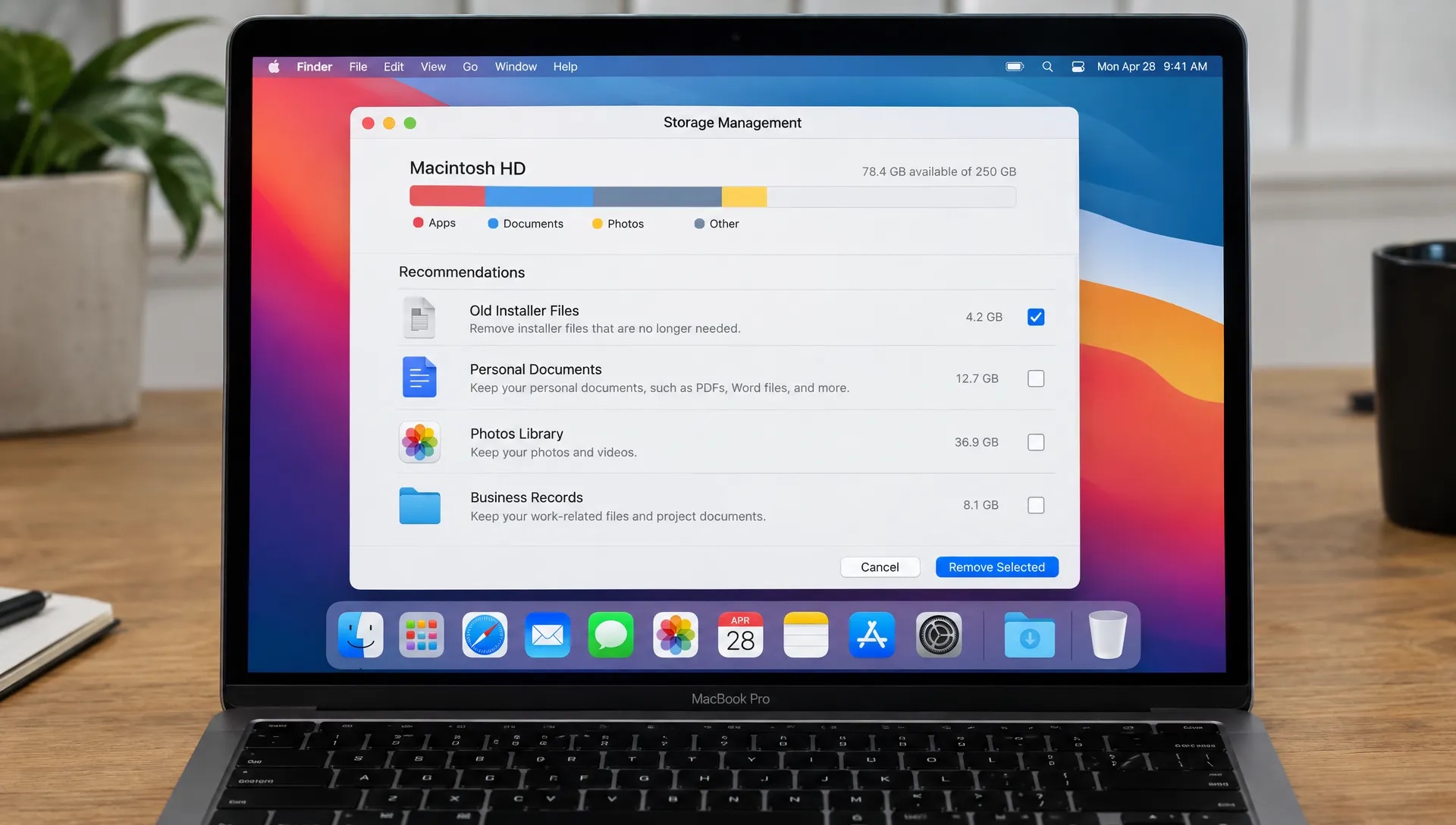 A MacBook screen faces the viewer with old installer files selected for removal, while personal documents, a photo library and business records remain unselected.